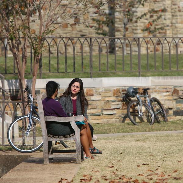 学生们在一个露天广场的长凳上讨论.